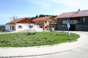 Dorfplatz des Ökodorfs Erlenweide mit Dorfbank.