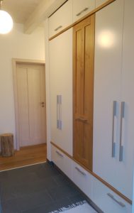 Garderobenschrank mit weißen Türen und Eichenholz